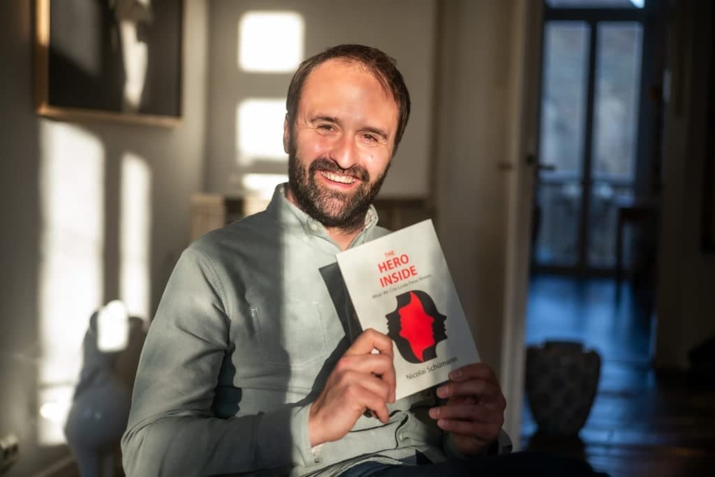 Nicolai Schümann holding his book The Hero Inside